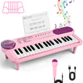 Teclado infantil rosa com microfone, suporte de partitura, cabo USB e folha de músicas sobre fundo branco.